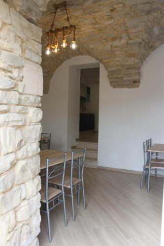 a dining room with a stone wall and a table and chairs at Il Viandante Bed & Breakfast in Roseto Valfortore