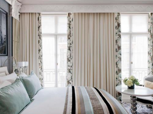 une chambre avec un lit, une table et des fenêtres dans l'établissement Sofitel Paris Le Faubourg, à Paris