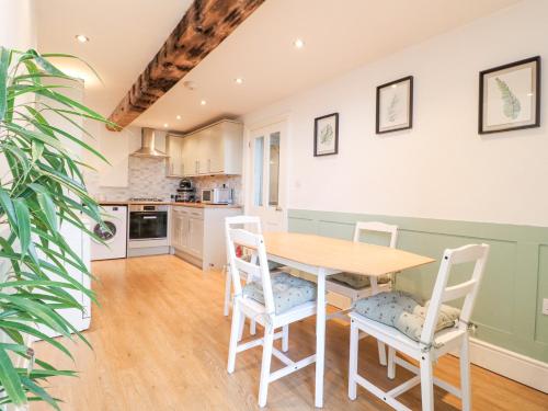 a kitchen and dining room with a wooden table and chairs at River Cottage in Derby