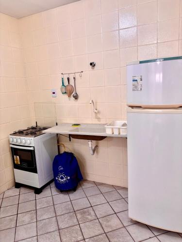 Una pequeña cocina con estufa y refrigerador. en 04 Apartamento São João, en Caruaru