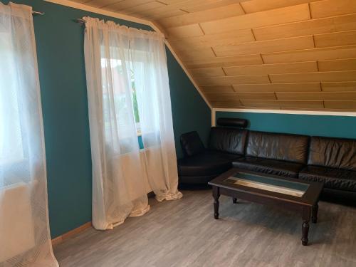 a living room with a leather couch and a table at Ferienwohnung Ortenau in Neuried