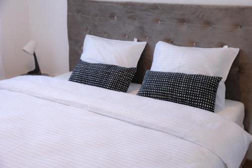 a white bed with four pillows on it at Apartman Mint&White Borik in Banja Luka