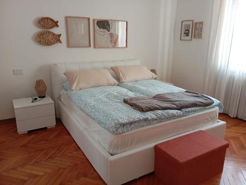 a white bed in a room with a table at Ca 'Romanel in Garda