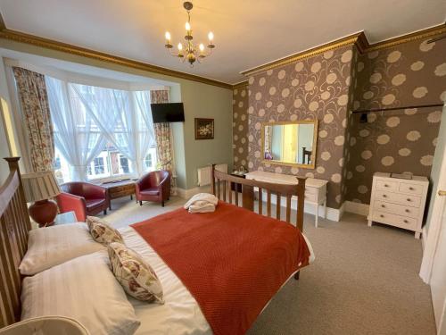 Un dormitorio con una cama, un escritorio y un espejo. en The Captain's Lodge Room Only accommodation, en Whitby