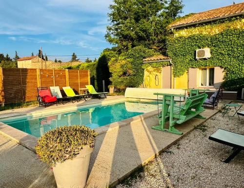 - une piscine avec une table et des chaises à côté d'une maison dans l'établissement Villa Provençale avec Jardin et Piscine Privée à Beaumes-de-Venise, à Beaumes-de-Venise