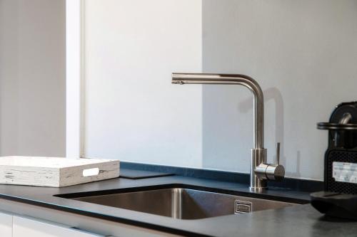 科莫Hidden Lodge - by MyHomeInComo的厨房柜台设有水槽和刀块