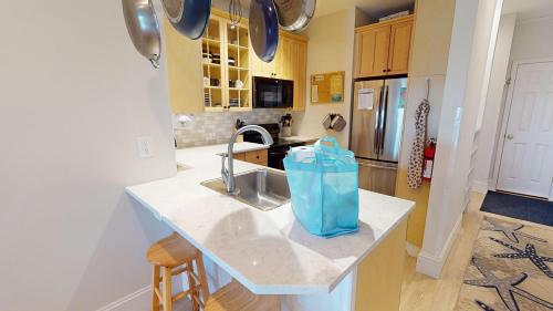 a kitchen with a counter with a blue bag on it at Pier Pleasure in Folly Beach
