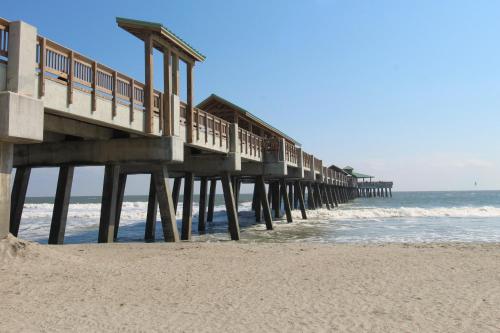 a pier on the beach next to the ocean at Pier Pleasure in Folly Beach