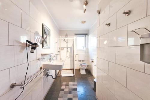 a white bathroom with a sink and a toilet at Ferienwohnung Franke 1 3 in Zinnowitz