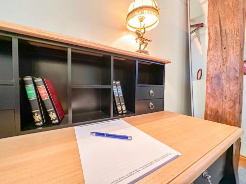 a desk with a pen on a paper on it at Château de Tilly in Boissey-le-Châtel