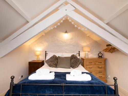 ein Schlafzimmer mit einem Bett im Dachgeschoss in der Unterkunft Rose Cottage in Cardigan