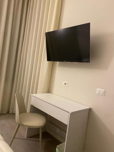 a desk with a chair and a television on a wall at Midtown Salerno in Salerno