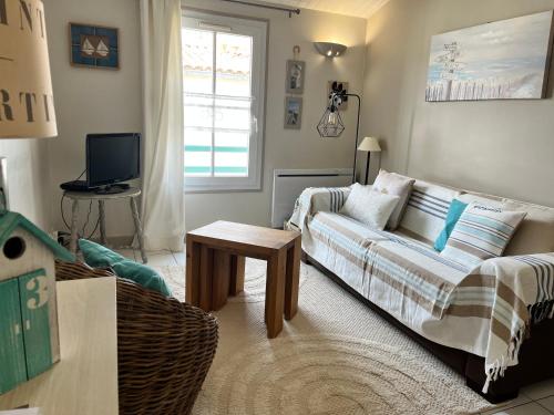 a living room with a couch and a table at Clos Vauban in Saint-Martin-de-Ré