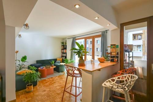 Il comprend une cuisine et un salon avec un bar et des chaises. dans l'établissement Charming T3 of 60 m2 with balcony in Marseille, à Marseille