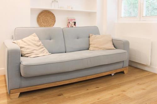 - un canapé bleu dans le salon dans l'établissement Charming apartment in the heart of the 18th, à Paris