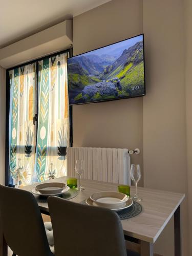 a dining room with a table and a tv on the wall at Turin Bicerin Green in Turin