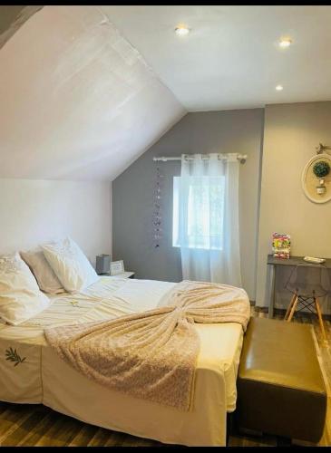 une chambre avec un grand lit avec une fenêtre dans l'établissement MAISON DE CHARME piscine chauffée, à Carlux