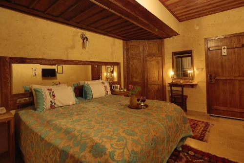 a bedroom with a large bed in a room at Jerveni Cave Hotel in Mustafapaşa