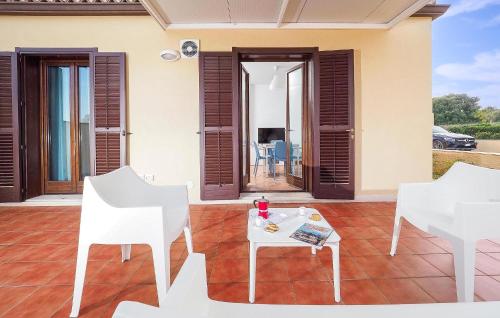 eine Terrasse mit zwei weißen Stühlen und einem Tisch in der Unterkunft Pet Friendly Home In Marina Di Modica in Marina di Modica