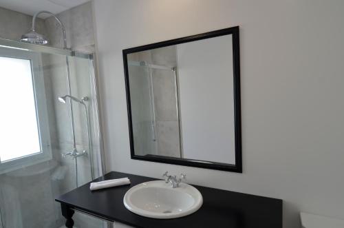 a bathroom with a sink and a mirror and a shower at Vila Toca in Funchal