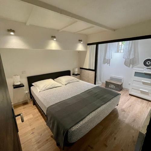une chambre avec un lit et une grande fenêtre dans l'établissement Appartement intra-muros bien situé et agréable à proximité des théâtres, à Avignon
