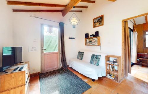 a living room with a white couch and a tv at Awesome Home In Val De Louyre Et Caude in Saint-Alvère