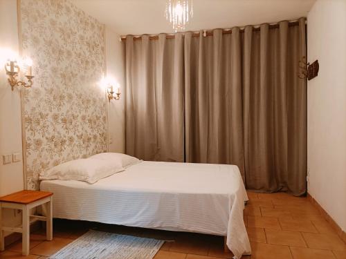 a bedroom with a white bed and a curtain at Ô Fil de la Durance in La Roque-dʼAnthéron