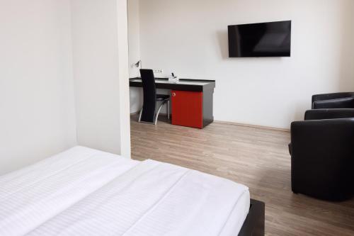 a bedroom with a bed and a desk and a chair at Hotel Villa-Bassermann, stilvoll, 2 Min zum Schloss, schnelles WLAN & Parkplatz in Schwetzingen
