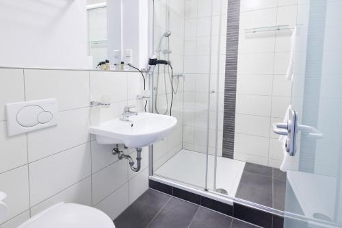 a bathroom with a shower and a sink and a toilet at Hotel Villa-Bassermann, stilvoll, 2 Min zum Schloss, schnelles WLAN & Parkplatz in Schwetzingen