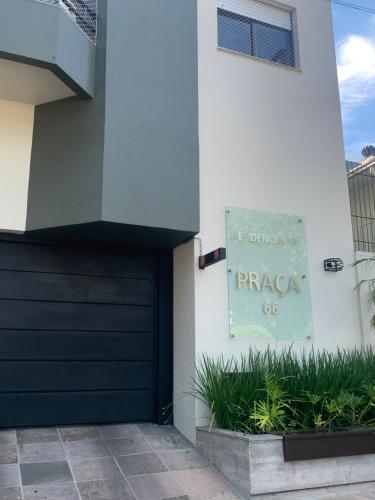 a building with a black garage door and a sign at Apartamento Champagne rosé in Garibaldi