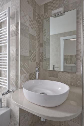 a bathroom with a white sink and a mirror at Tenuta il Bosco con parcheggio in Bitonto