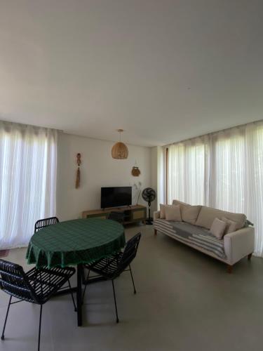 a living room with a couch and a table and chairs at Casa Brisa - sossego a 50 mts da Praia da Bombaça em Barra Grande in Marau