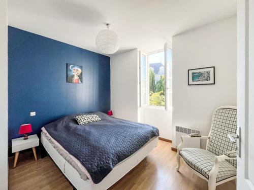- une chambre avec un mur bleu, un lit et une chaise dans l'établissement Holiday Home Rimbo by Interhome, à Saint-Georges-dʼOléron