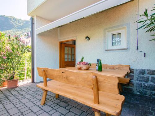 a wooden bench sitting outside of a house at Apartment Neuhaus by Interhome in Andrian