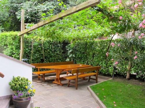 a wooden picnic table and benches in a garden at Apartment Neuhaus by Interhome in Andrian