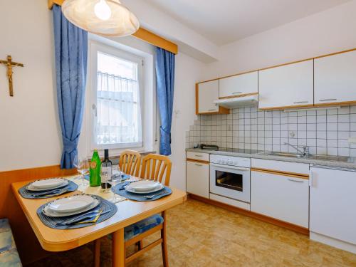 a kitchen with a wooden table with plates on it at Apartment Neuhaus by Interhome in Andrian