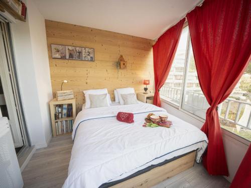 - une chambre avec un grand lit blanc et des rideaux rouges dans l'établissement Apartment du Parc II-10 by Interhome, à La Grande Motte