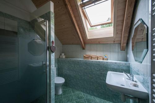 a bathroom with a sink and a toilet and a window at Penzion Krakovice in Kaplice