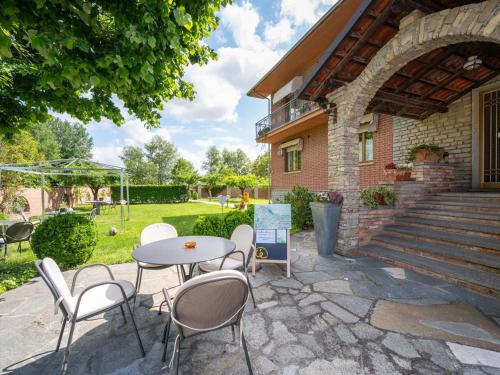 a patio with a table and chairs in front of a building at Apartment Ca' D'Gnese by Interhome in Castagnole Lanze