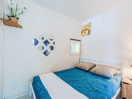 une chambre avec un lit avec une couverture bleue dans l'établissement Apartment Parc de la Mer-12 by Interhome, au Barcarès