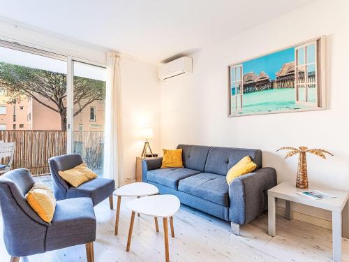 un salon avec un canapé bleu et deux chaises dans l'établissement Apartment Saint Antoine-3 by Interhome, à Saint-Tropez