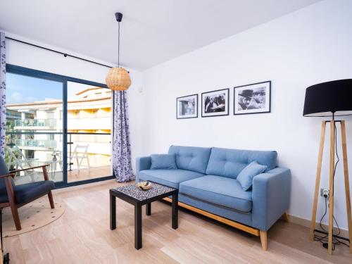 a living room with a blue couch and a table at Apartment Cala Mora by Interhome in Moraira