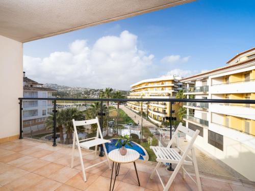 a balcony with chairs and a view of a city at Apartment Cala Mora by Interhome in Moraira