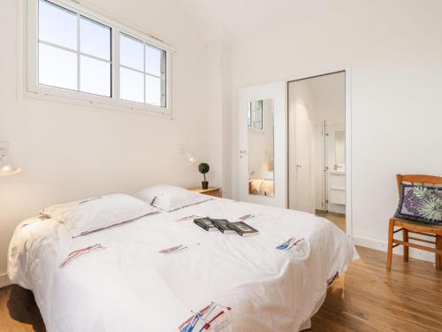 - une chambre avec un lit blanc, une fenêtre et un miroir dans l'établissement Holiday Home La Floriette by Interhome, à Dinard