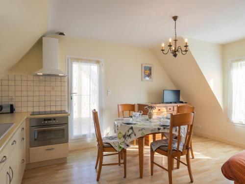 une cuisine et une salle à manger avec une table et des chaises dans l'établissement Holiday Home Hortensias by Interhome, à Clohars-Carnoët