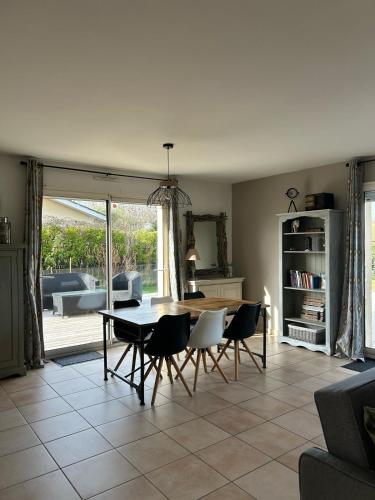 un salon avec une table et des chaises de salle à manger dans l'établissement Gite des Pins, à Aureilhan
