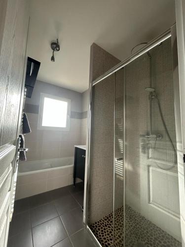 La salle de bains est pourvue d'une cabine de douche en verre. dans l'établissement Gite des Pins, à Aureilhan