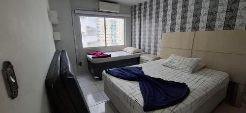 En eller flere senge i et værelse på Apto espaçoso uma quadra do mar com garagem