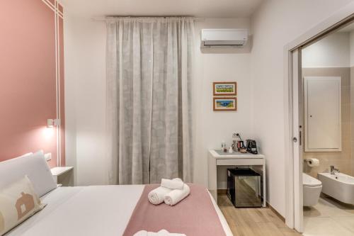 una camera da letto bianca con un letto e un bagno di Caravita Rooms a Napoli