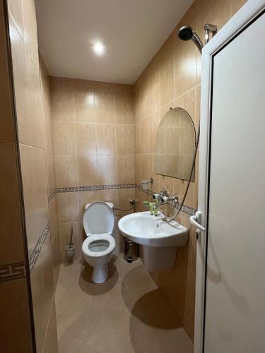 a bathroom with a toilet and a sink at Hotel Lazur in Kiten